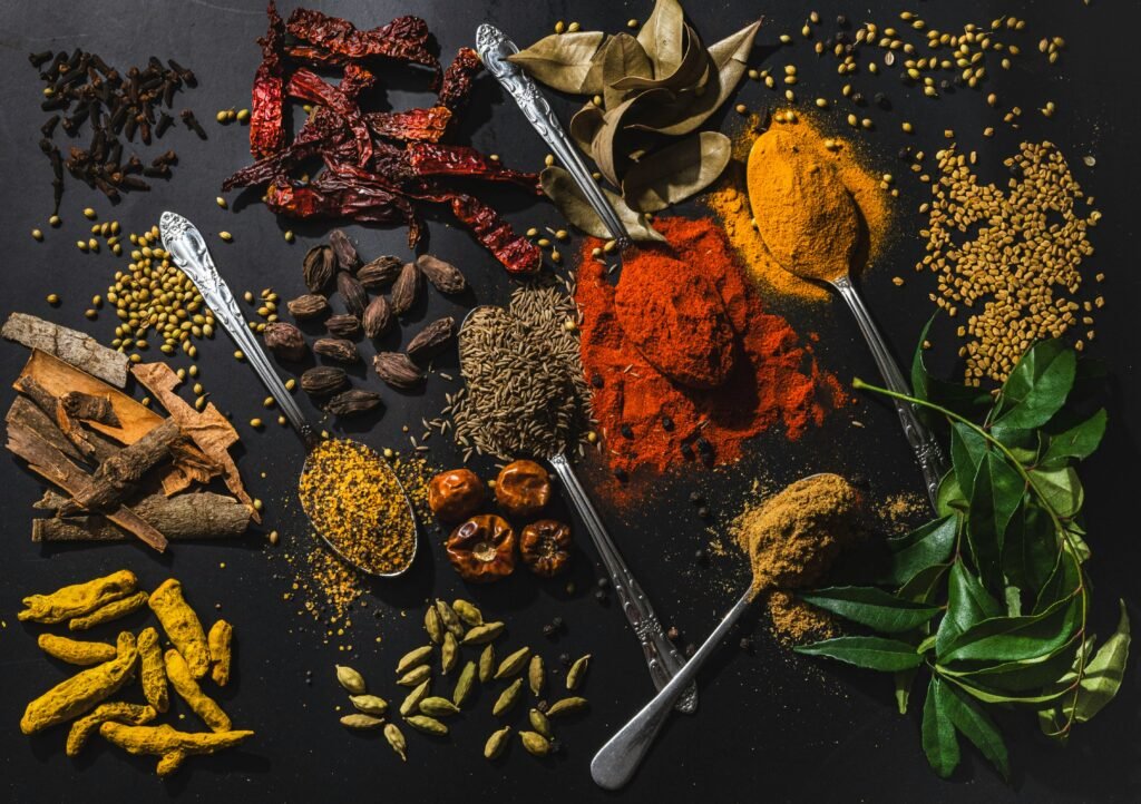 Assorted Indian spices in bowls on a wooden surface