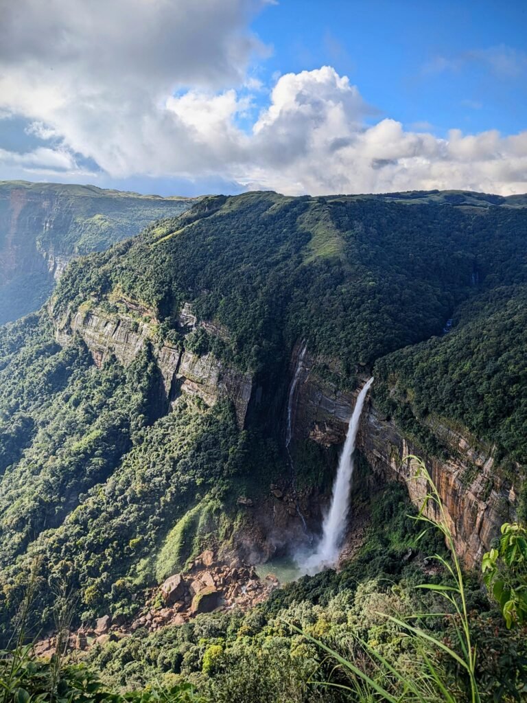 Nohkalikai Falls plunging from a high cliff into a turquoise pool in Cherrapunji, Meghalaya