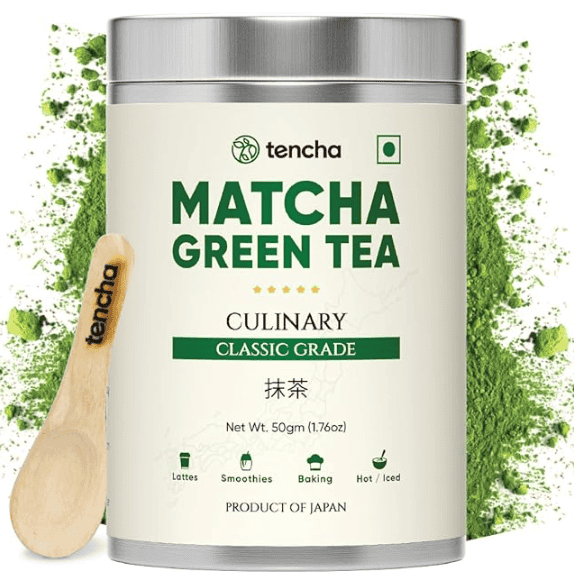 A bowl of bright green matcha tea with a whisk.