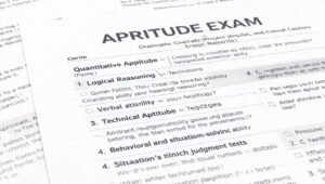Graphic showing Aptitude Exam sections: Quantitative Aptitude, Logical Reasoning, Verbal Ability, Technical Aptitude, Coding Aptitude, Analytical Problem-Solving, and Behavioral Judgment Tests