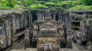 Historic rock-cut temple complex carved into stone cliffs with detailed sculptures and ancient architecture.