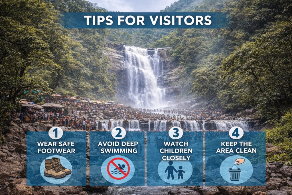 Visitors walking safely on wet rocky path near Kutralam waterfalls wearing footwear